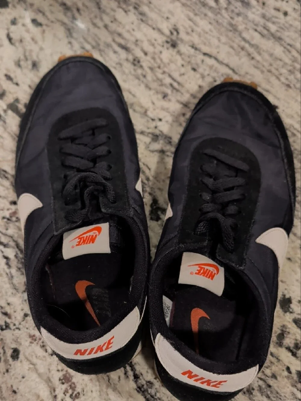 Nike Black Sneakers with White Swoosh and Orange Tongue Logo